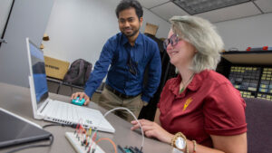 Engineering major Gwen Eging (right) works with faculty mentor Ayan Mallik (left) to design batteries that are charged by movement for applications such as wearables.