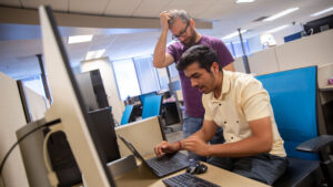 Computer science major Vishal Juneja (foreground) works with faculty mentor Yan Shoshitaishvilli (background) on a project to improve the security and reliability of software by improving the Google error-detecting tool called AddressSanitizer.