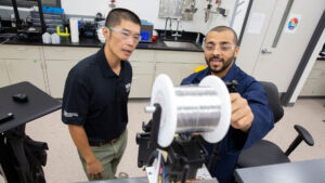 Manufacturing engineering graduate student Mohammed Bawareth (right) works with faculty mentor Keng Hsu on a MORE research project to advance the understanding of how an additive manufacturing technology that uses sound vibrations can improve the energy efficiency of metal 3D printing.