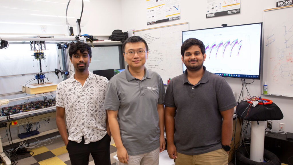 Three researchers in a robotics lab.