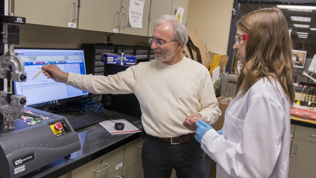 Vincent Pizziconi works with a student researcher in his lab.