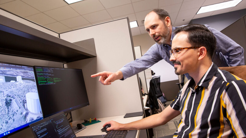 ASU engineering faculty member Paul Grogan works with a student in his lab. 