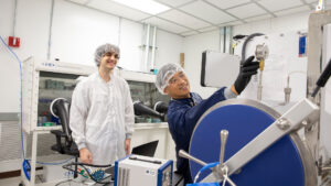 Zeyad George's mentor Yoon Hwa points at a gauge in a lab.