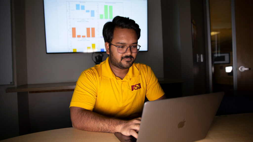 Kumar Satvik Chaudhary types on a laptop.