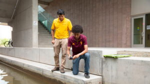 Ahadu Assegued uses a device to analyze a body of water.