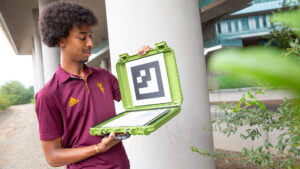 Ahadu Assegued looks at a QR code in a plastic case-like device.