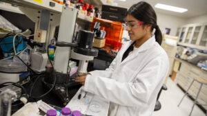 Munia Ahmed works with equipment in a lab.