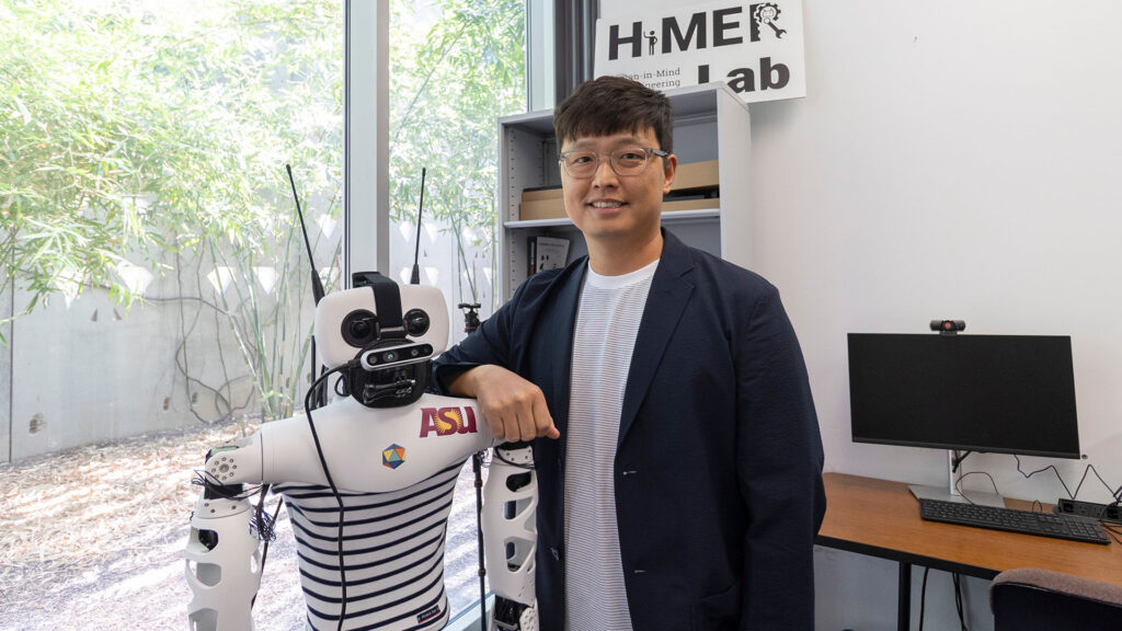 Heejin Jeong poses in an office with a robot.